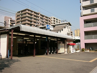 同じ建物を左斜めに見て。右真中に屋根と壁で囲われた跨線橋の階段が上っている。