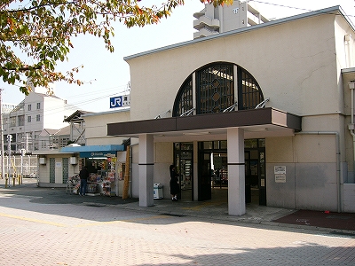 駅舎を間近に右斜めに見て。大きなファンライトとがあり、その下にポーチがある。入口はファンライトの大きさに合わせてある。