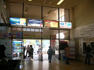 駅からの出口を見て。2階分の高さの間口が薄茶色のガラス張りになっている。