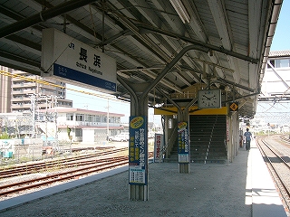 山型の屋根の白い上屋の下で。上屋はホーム中央にある柱で支えられている。