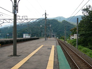 長く太いホームの終わる50mぐらい手前。線路の伸びる向こうは山にぶつかってトンネル。