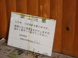 長椅子の上に立てかけられてある頭上注意のプレート