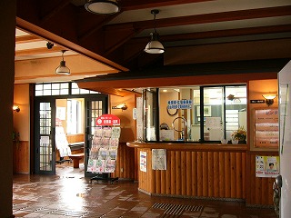 濡れたタイルの地面、展示室入り口、庇のある出札口