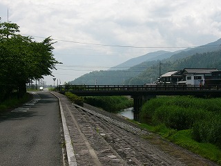 緑の川、橋、山、曇り空。