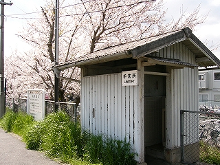 扉の無い切妻屋根の小型の古くさそうな手洗所。