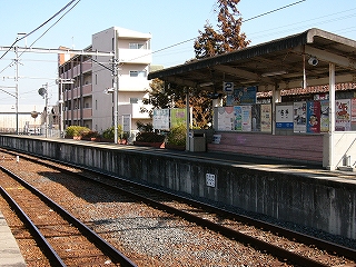 ピンクの長椅子と背もたれの壁、それを覆う屋根が1セットになった2番線待合所を線路内とともに見て。