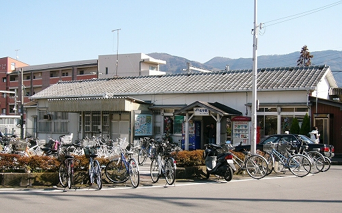 瓦屋根の横長の駅舎。白塗りの木造。