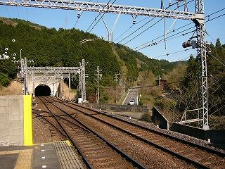 白い坑口。右向こうに国道が上っている。