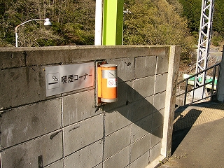 空き缶のようなものを壁に掛けた灰皿。