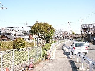 ガードレールのある歩道。左手には掘割の線路内。