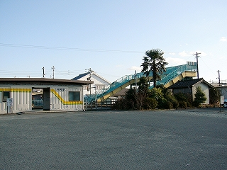 駅舎とヤシの木のある庭、そして小さな木造のトイレ。
