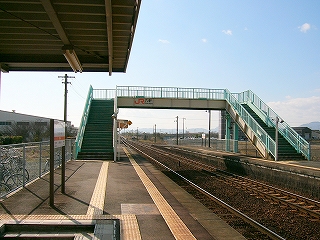 柵が緑色に塗られた屋根なしの跨線橋。