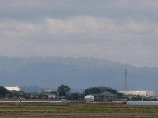 高い倍率でやっと撮影。稜線にごく小さく白い風車が立ち並んでいる。