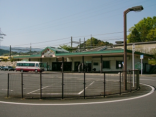 柵で囲まれたロータリーと駅舎。