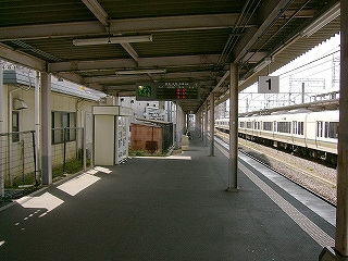 陸屋根の上屋から発車案内の電光掲示が吊られている。ホームに人影がない。