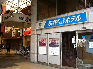 ビジネスホテルの小さな入り口。左向こうにアーケード商店街が続く。