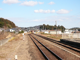 伸び行く二線。遠くの方に住宅。