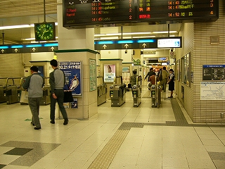 自動改札の並びと大きな電光掲示板。