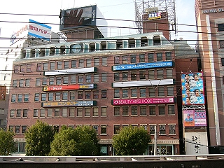 広告の目立つレンガ積みの概観のビル。