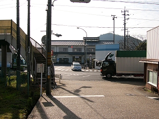 交差点に出る少し前から撮影。奥の方に駅舎が見える。左手には歩道協和を足るためのカーブを描いた階段。