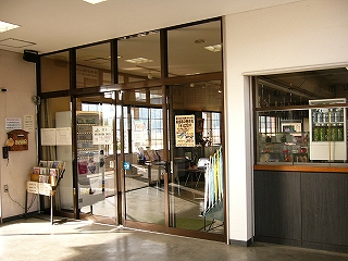 こちらも大きいガラス戸を4枚並べた食事処の入り口。その入口の右には、駅舎内に向かって造られた飲み物を売る小さなカウンターが造られてある。