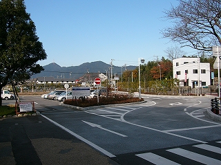 ロータリーの中央部分とその脇に駐車スペースを作った駐車場。遠くには少し鋭さを削ったような山なみ。