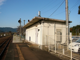 ホームのはずれにある白い平屋の建物を斜めに見て。