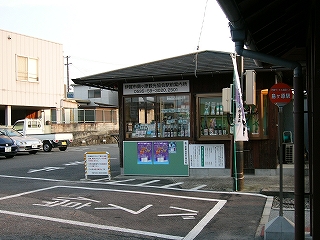 平屋の小さな建物。屋根は薄い四角錐で、窓ガラスに向かって商品が陳列されている。