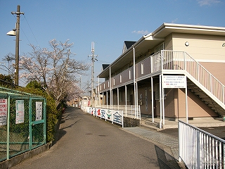新築アパートとゴミ集積所と駅前の道路。