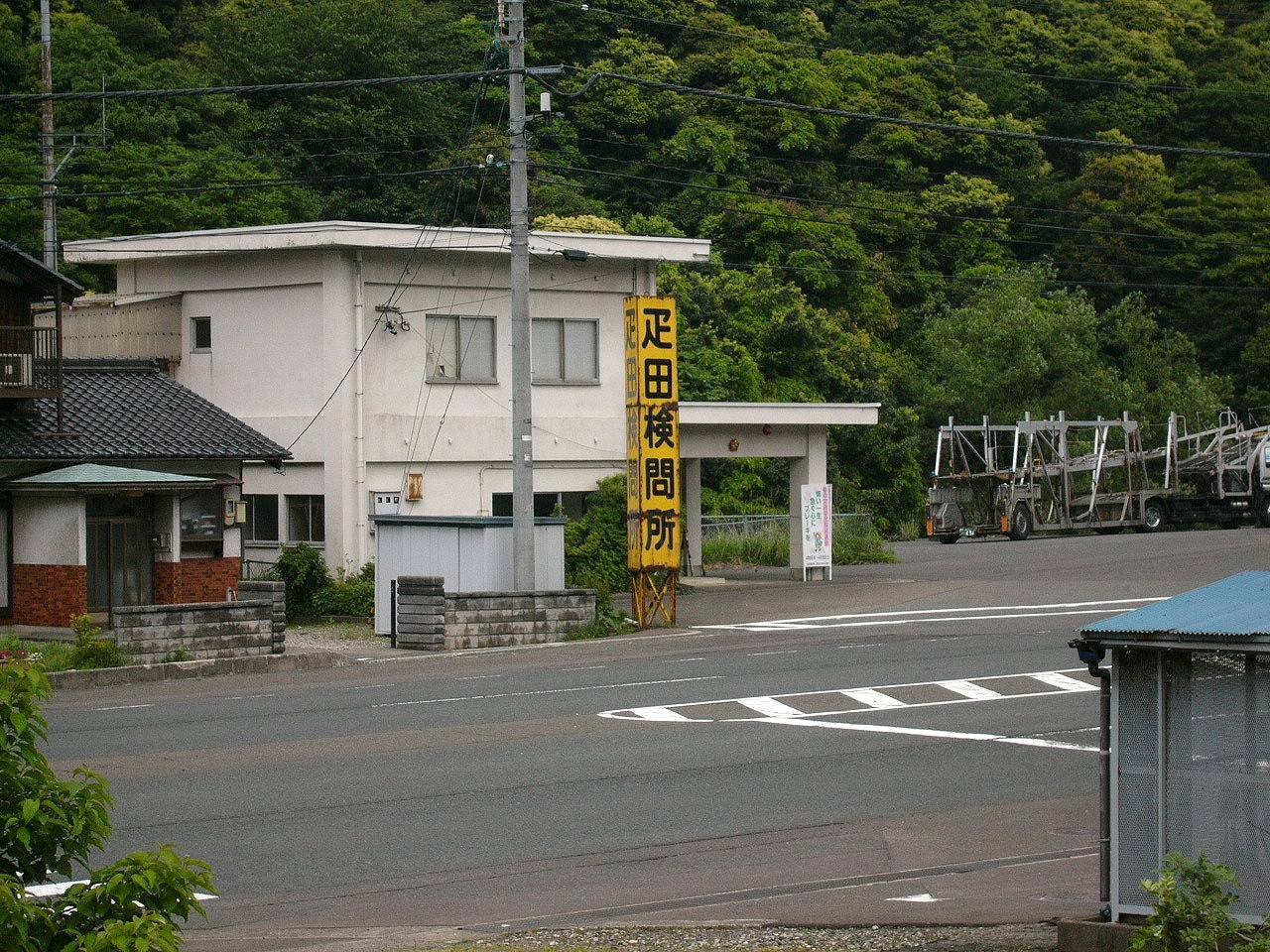 一階が駐車場の四角い感じの白い2階建ての建物