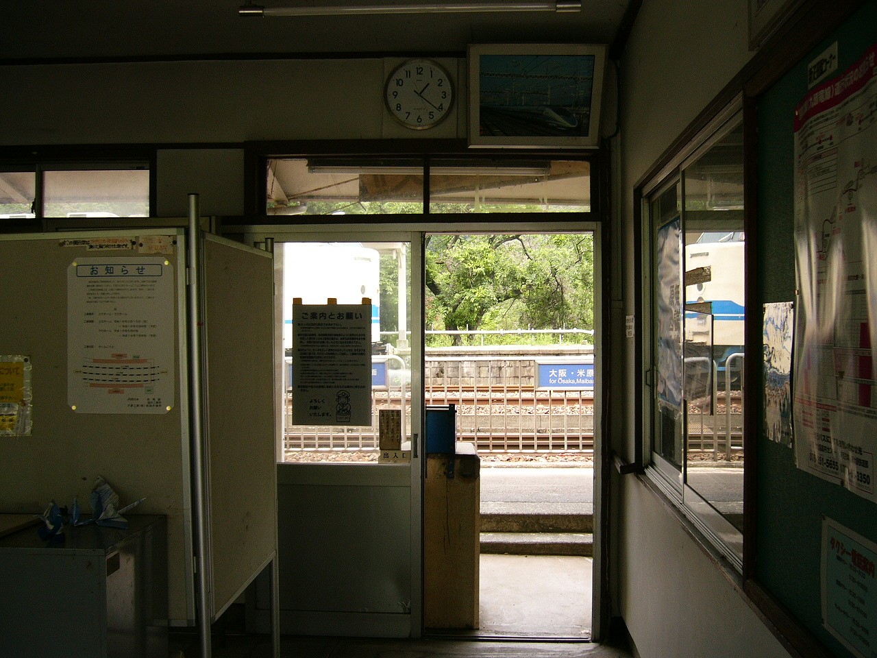 無機質なボードや事務用ロッカーが置かれ雑然とした駅舎内