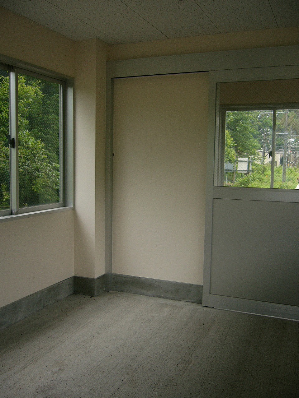 まだ何も置かれていない床はセメント塗りのまっさらな待合室の中