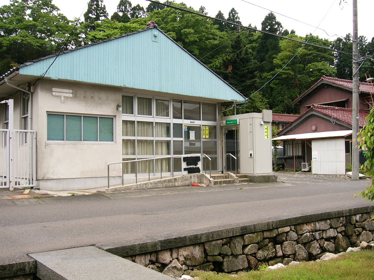 水色の大きな切妻の平屋の旧郵便局