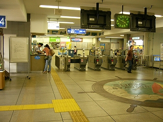 クリーム色のタイルを敷き詰めたコンコースと自動改札。