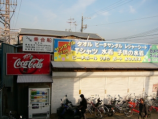 白いシャッターの下りた屋根看板のある海の家。