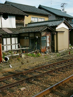 壊れかけた民家と線路