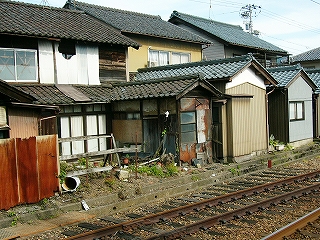 壊れかけた民家と線路