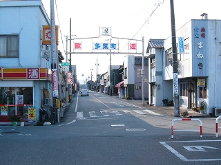 「歓迎　多気町」の門。両脇に建物。
