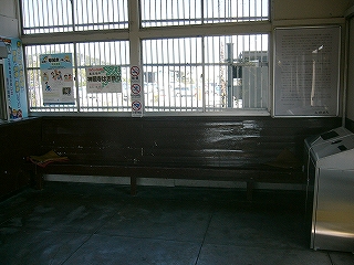 窓の下に据え付けられたこげ茶色の長椅子。