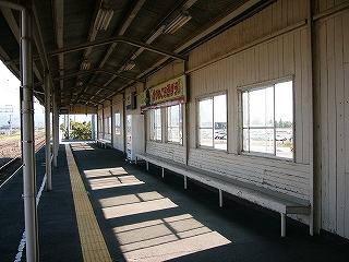 ホームと、ホームの背後の木造の壁。