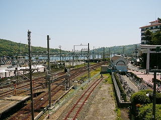 線路は遠くで右にカーブ。さらに遠くに海と山が見える。