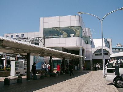 白いかなり大きなタイルを貼り付けた駅舎。コーナーがカーブしている。