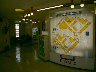 かなり大きな内照式案内板。奥のほうにソファを置いた小さな待合所。