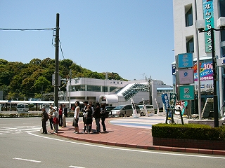 信号待ちしている人々、その遠くに近鉄の駅舎。