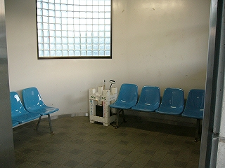 青い一人がけの椅子の並ぶ居室内。