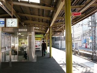 角が丸みを帯びたステンレスの待合室。上屋は黄色い柱で支えられている。