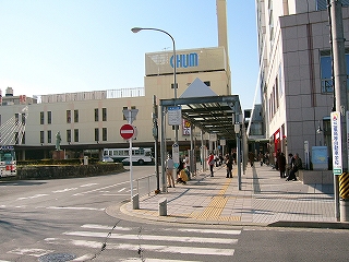 簡単なつくりのバスのりば前の屋根。奥には駅舎が見えている。