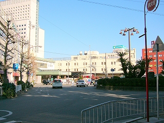 右手にロータリーの中央部、左手に駅へと続く幅が広く短い道路。