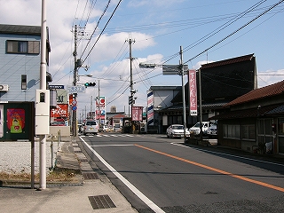 平屋の古い民家、その他新しい建物の混在する沿道。