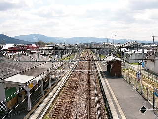まっすぐ伸びる線路内。遠くの方に山々が霞んでいる。